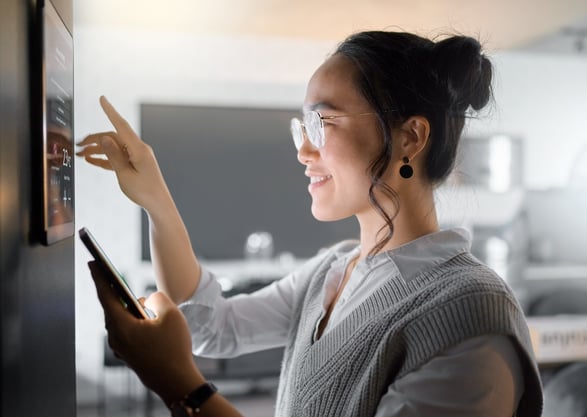 Person using a smartphone to access a smart home control panel, highlighting online privacy and personal cybersecurity for connected devices.