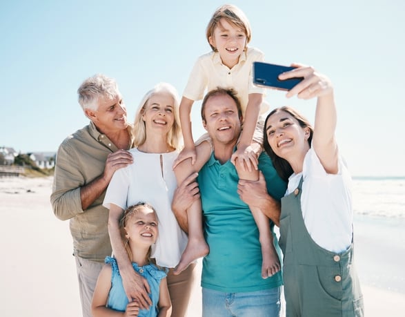 Family taking a beach selfie together, highlighting the importance of online privacy and protecting personal information online when sharing photos.